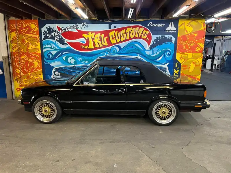 Black classic BMW E30 convertible with gold mesh wheels