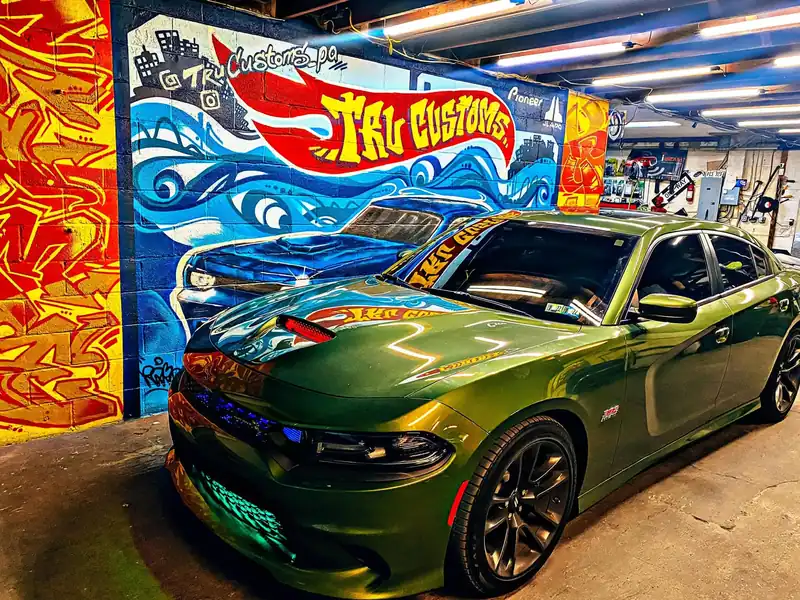 Green Dodge Charger Scat Pack with a lit hood scoop