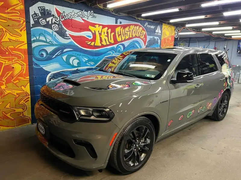 Gray Dodge Durango with colorful flower graphics on the hood and sides