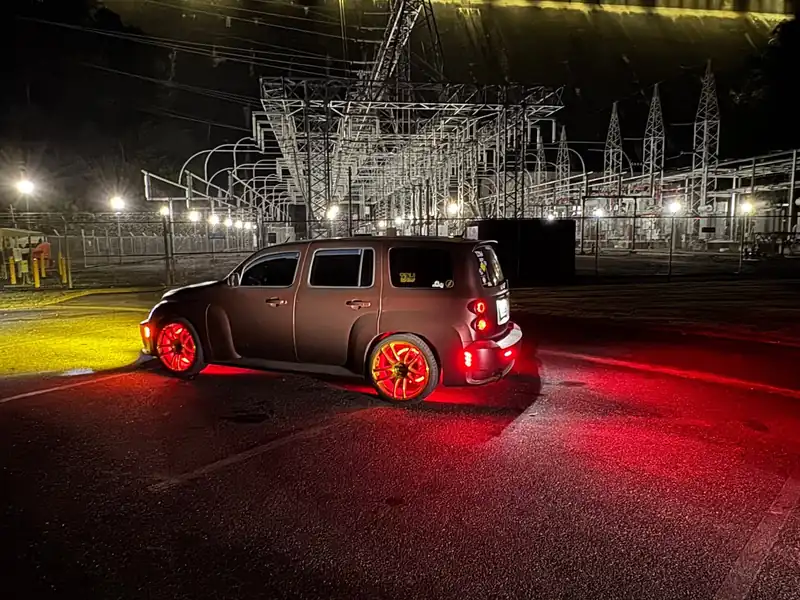 Chevrolet HHR at night with red LED wheel rings and underglow lighting the pavement