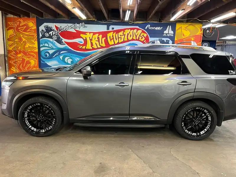 Gray Nissan Pathfinder with gloss black aftermarket wheels