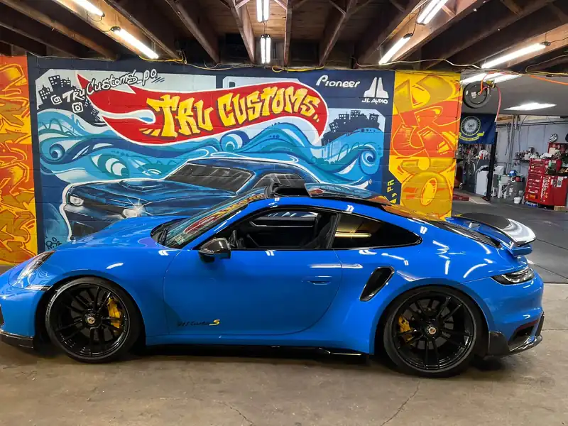Bright blue Porsche 911 Turbo S with black wheels and yellow brake calipers