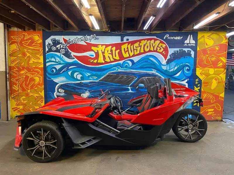 Red Polaris Slingshot in front of the TRU Customs mural