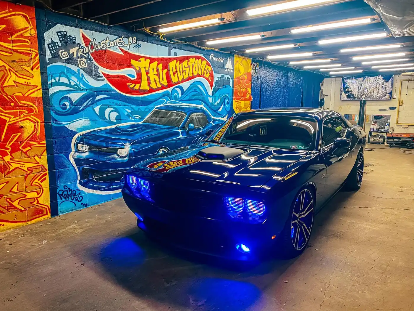 Dark blue Dodge Challenger with blue LED headlight rings, fog lights and underglow